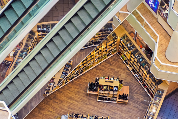 Einkaufladen von oben Fotografiert. Einkaufsfläche und Rolltreppen zu sehen.